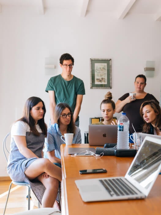 Une équipe en formation Canva autour de leurs ordinateurs
